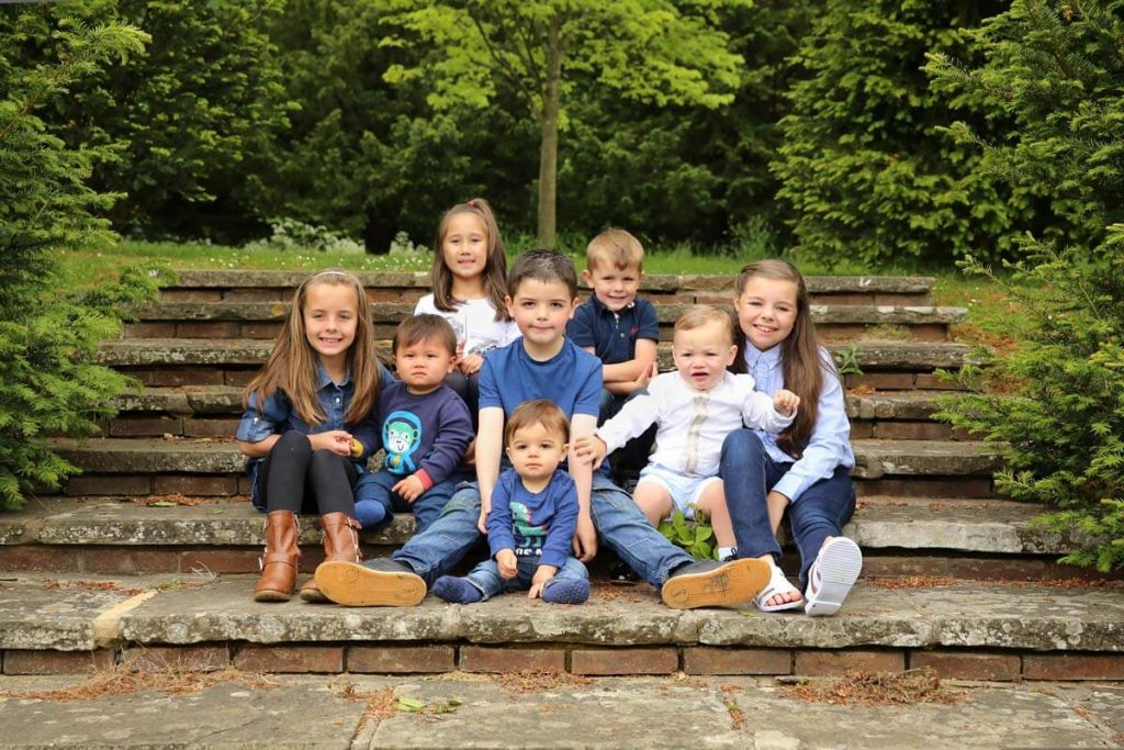 Eastbourne_family_photography_gildridge_park_powell-ful_photography eight children sitting on some steps outside