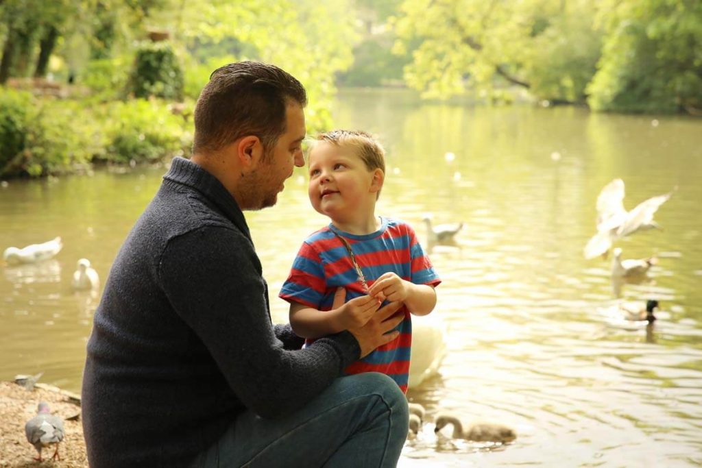 Eastbourne_family_photographer_hampden_park_powell-ful_photography.1 bad and son by lake feeding ducks