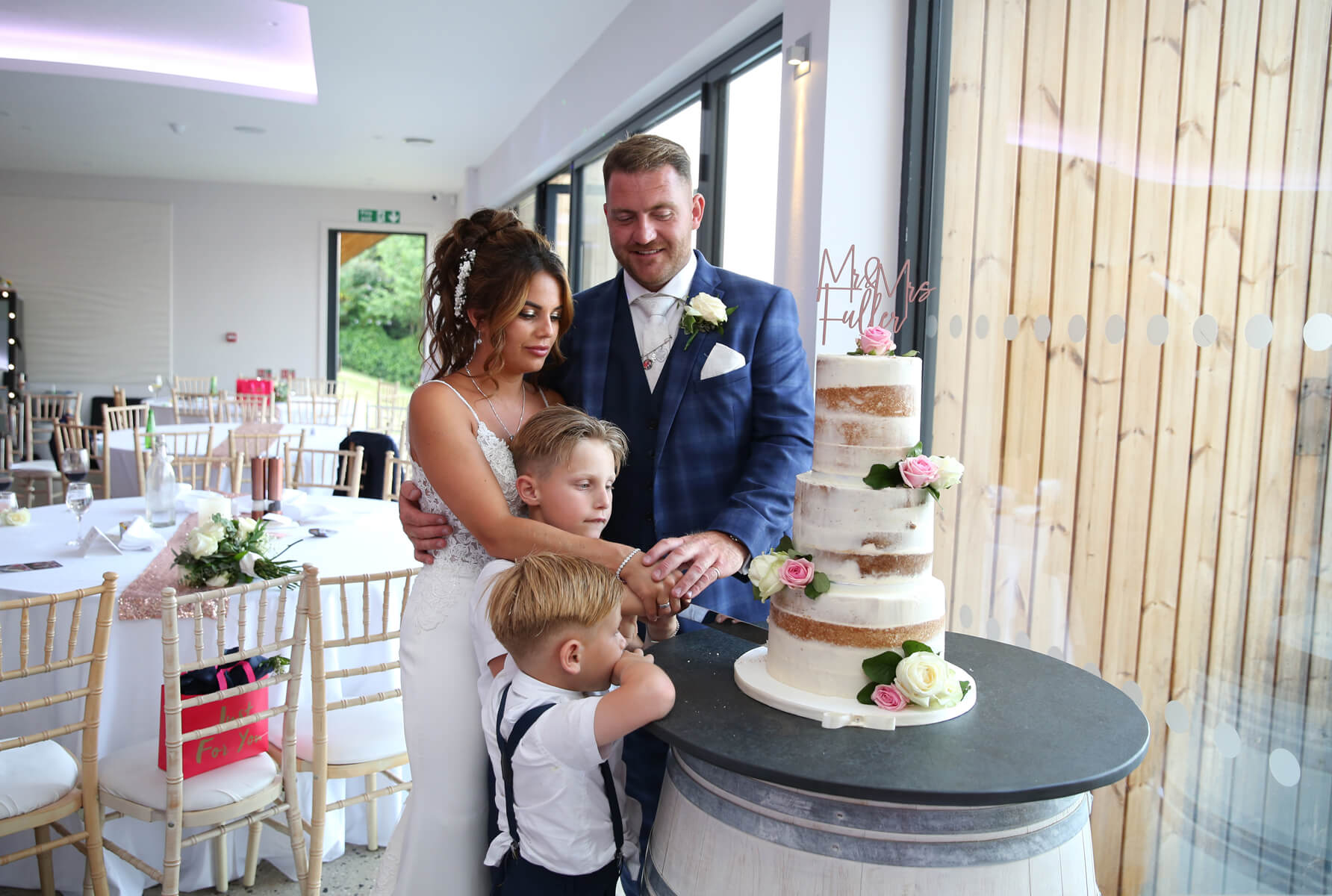 bride and groom and children cutting a wedding cake