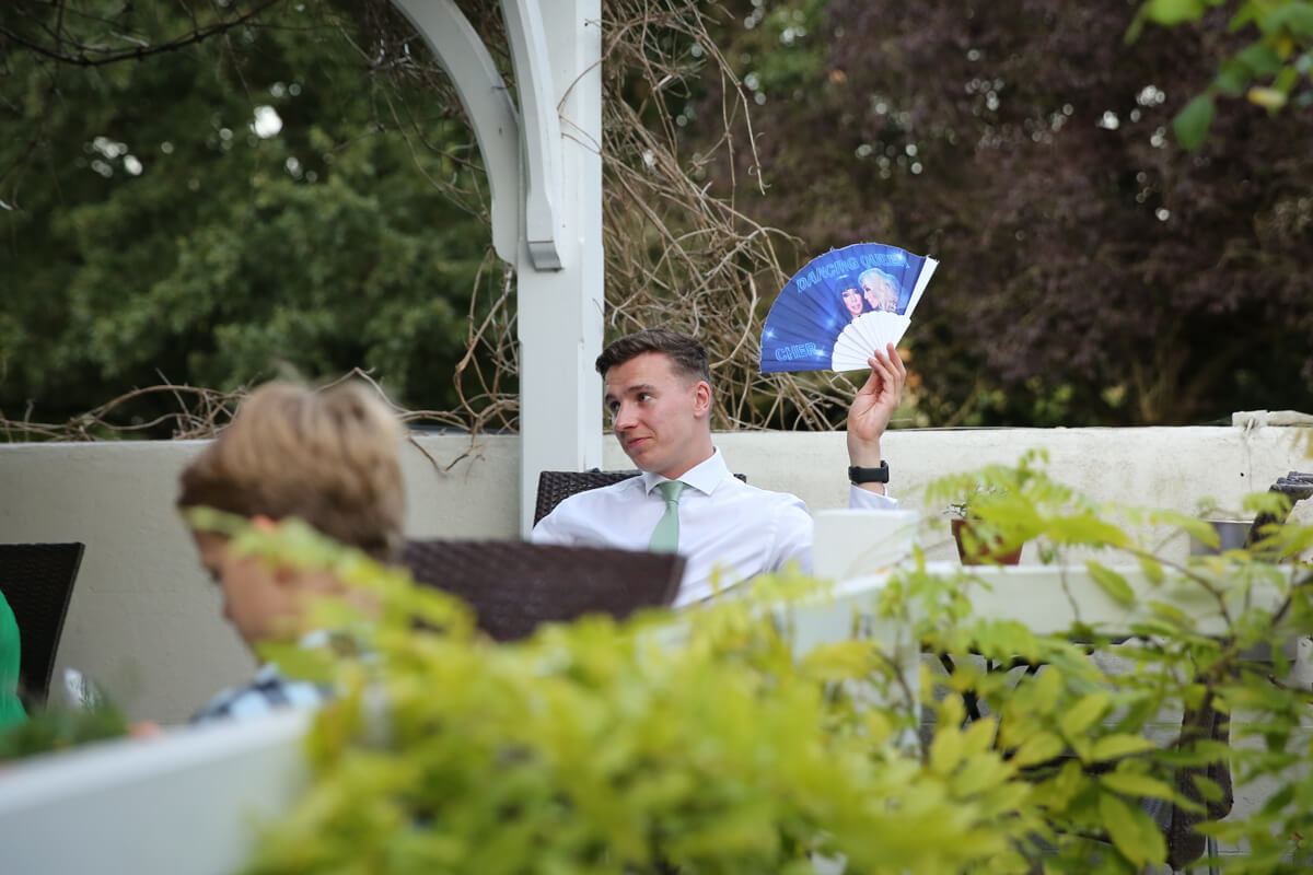 male wedding guest fanning himself