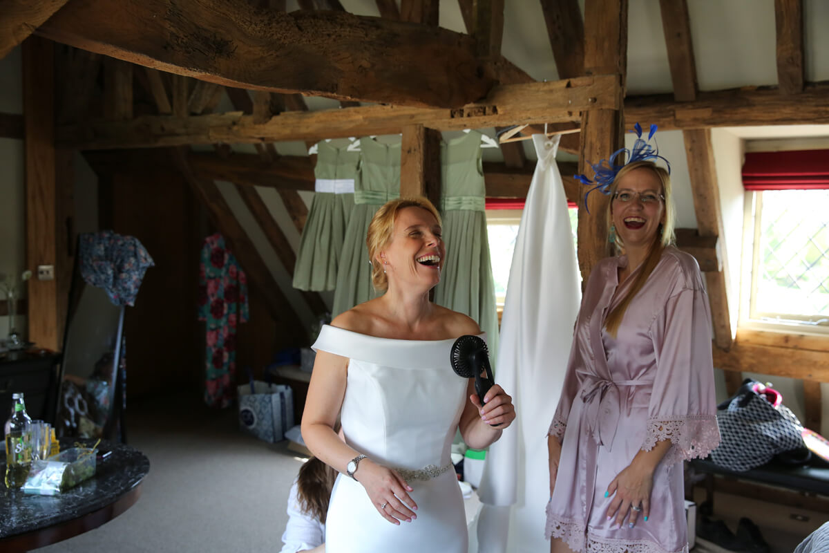 bride laughing with a fan in her hand