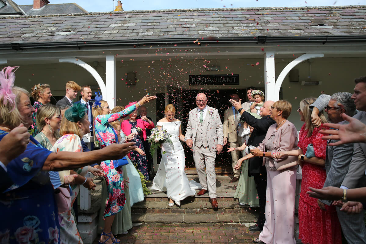 bride and groom walking through confetti