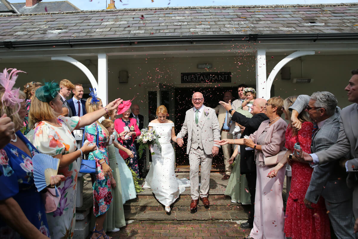 bride and groom walking through confetti