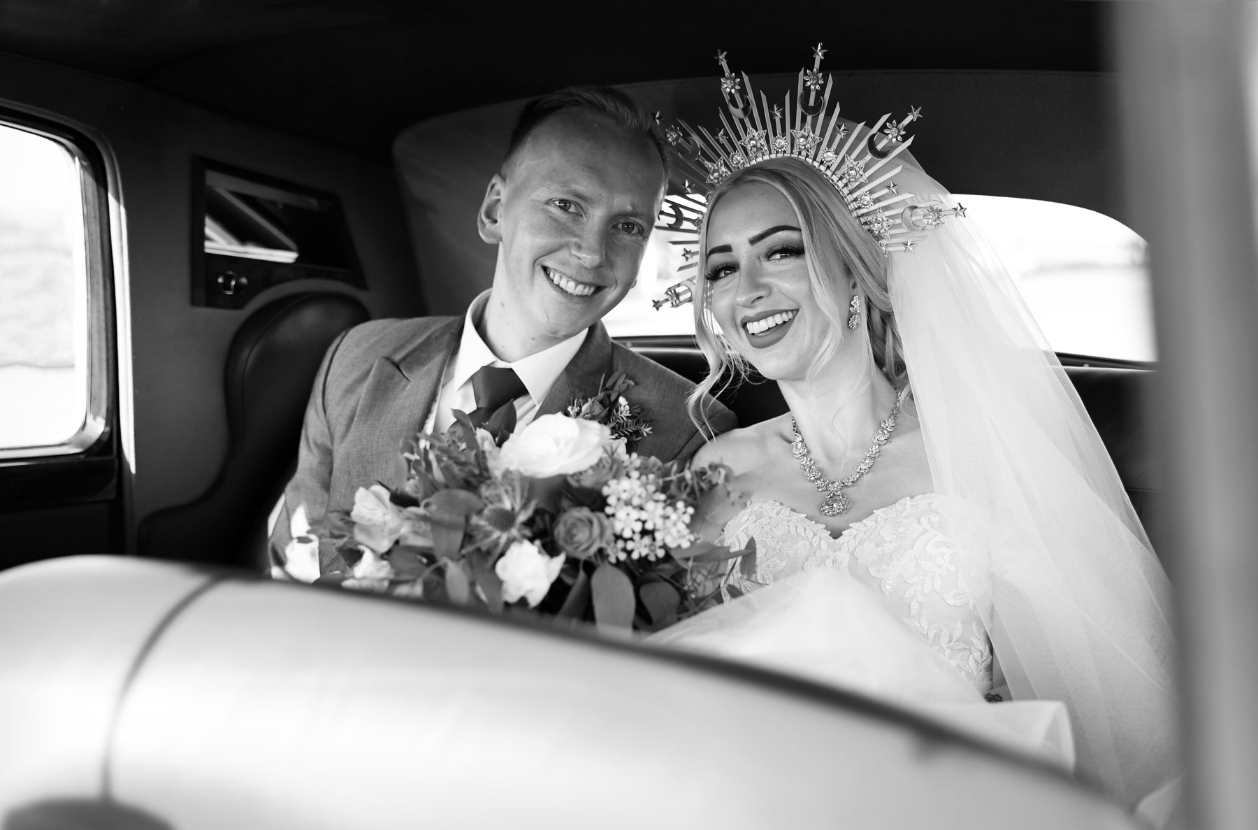 Wedding_Photographer_Eastbourne_The_Grand_hotel_powell-ful_photography bride and groom in a wedding car smiling at the camera wedding photography Eastbourne