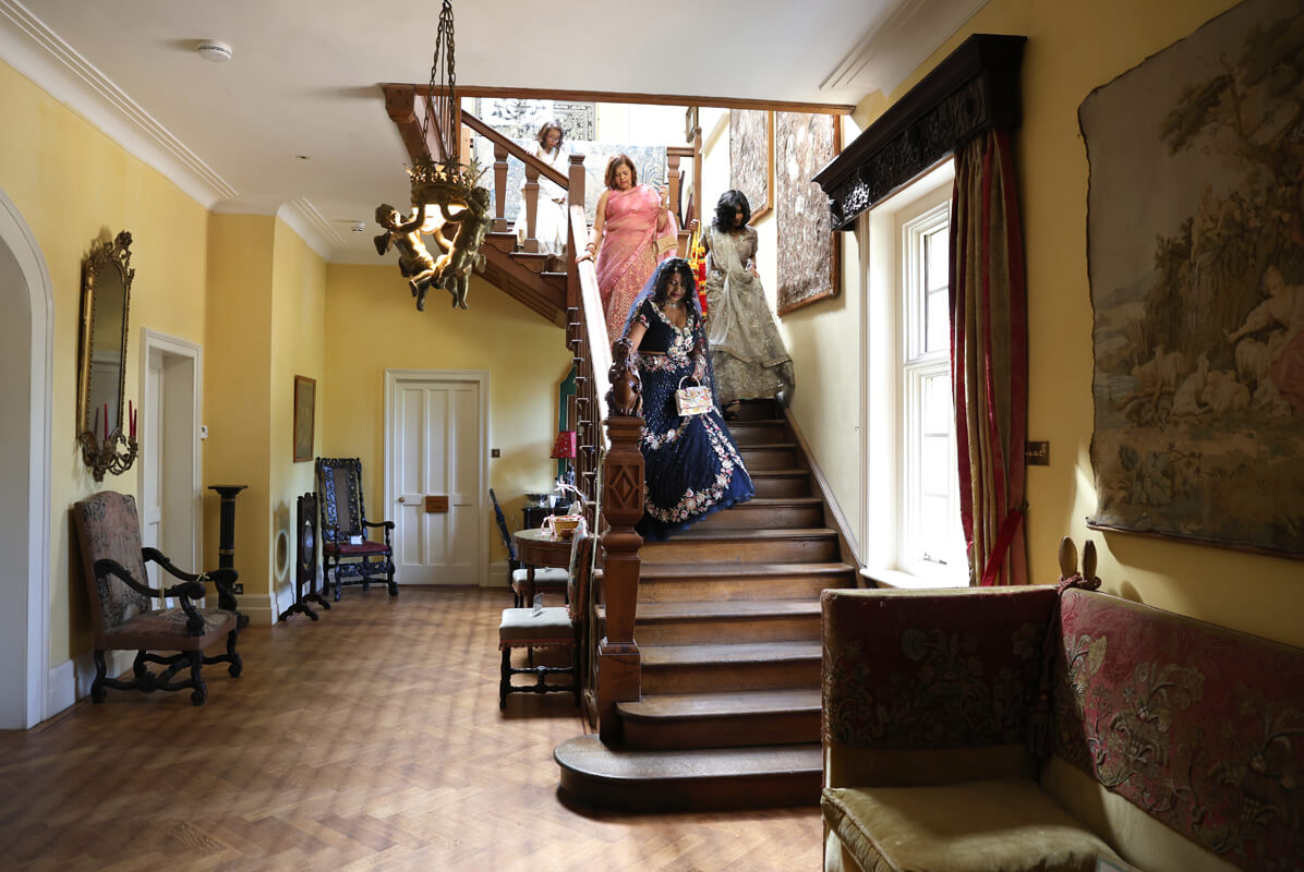Indian wedding at Wadhurst Castle bride coming down the stairs