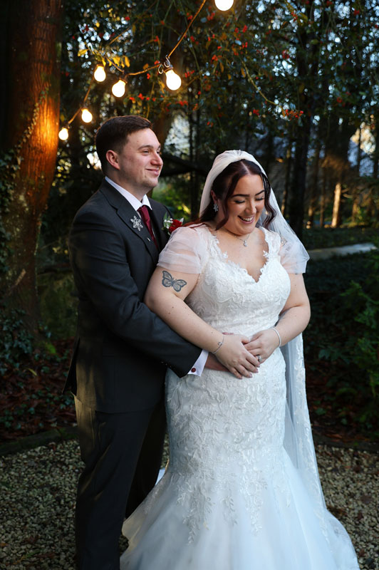 groom standing behind his bride with his arms around her